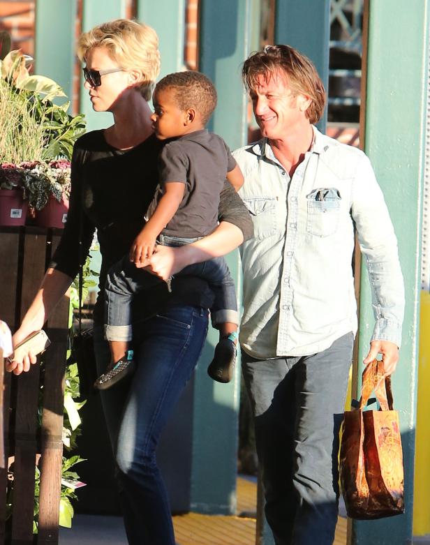 Charlize Theron und Sean Penn mit einem Kind im Arm.