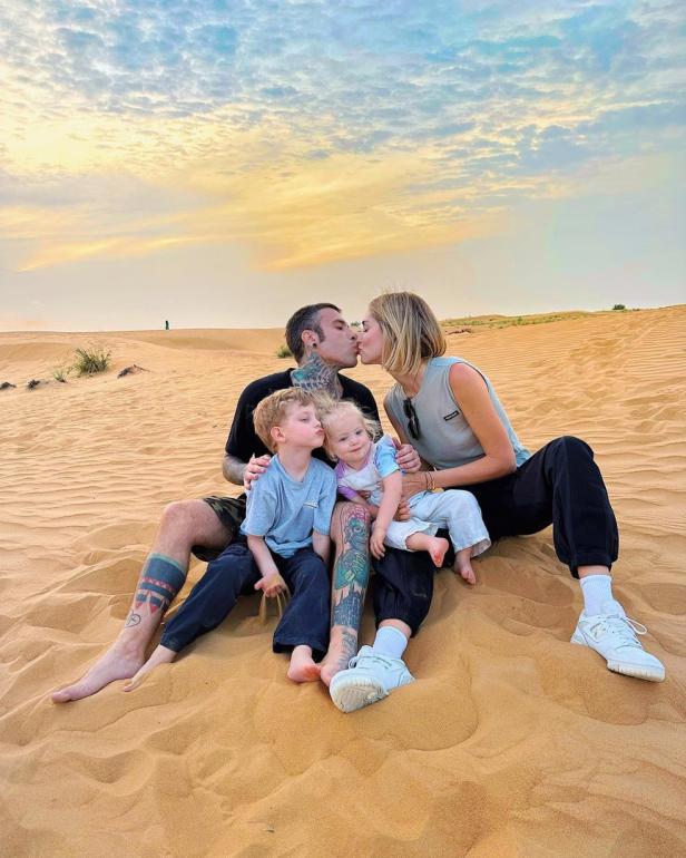 Chiara Ferragni und Fedez küssen sich mit ihren Kindern in einer Wüste.