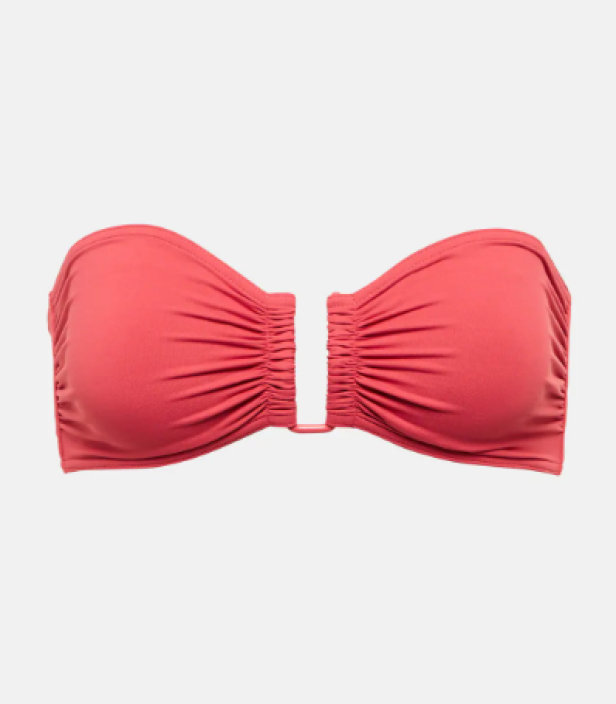 Ein korallfarbenes trägerloses Bikini-Oberteil mit Raffungen und einem dekorativen Ring in der Mitte.