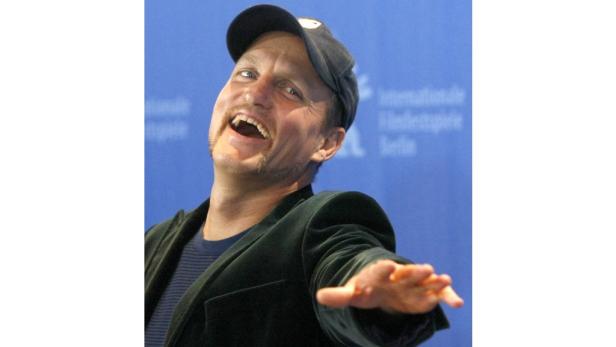 Woody Harrelson lächelt und streckt seine Hand aus.