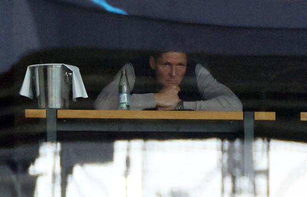 Ein Mann schaut hinter einer Bar hervor, auf der ein Eiskübel und eine Wasserflasche stehen.