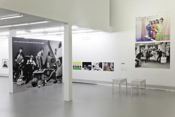 Innenansicht einer Kunstausstellung mit Fotografien und dem Schriftzug „I don't smoke don't drink and I don't have love affairs“.
