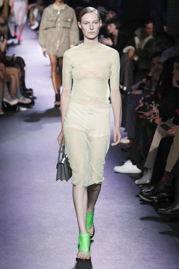 Ein Model auf dem Laufsteg in einem transparenten, hellgrünen Miu Miu-Ensemble.