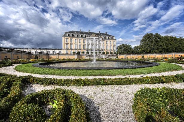 Schloss Augustusburg in Brühl mit einem Springbrunnen im Vordergrund.