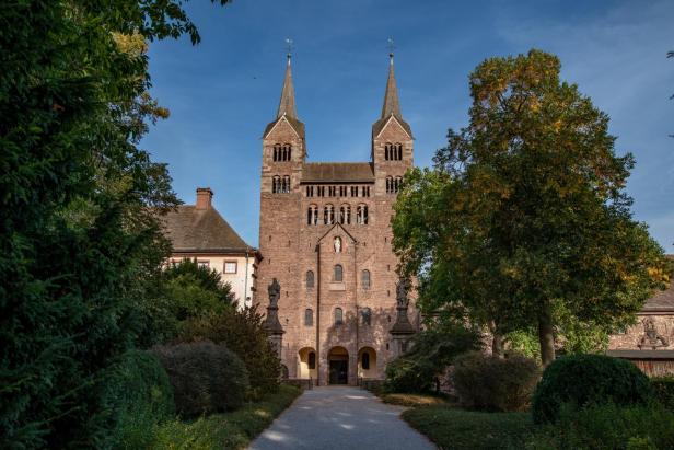 Die Abtei Corvey mit ihren markanten Doppeltürmen unter blauem Himmel.