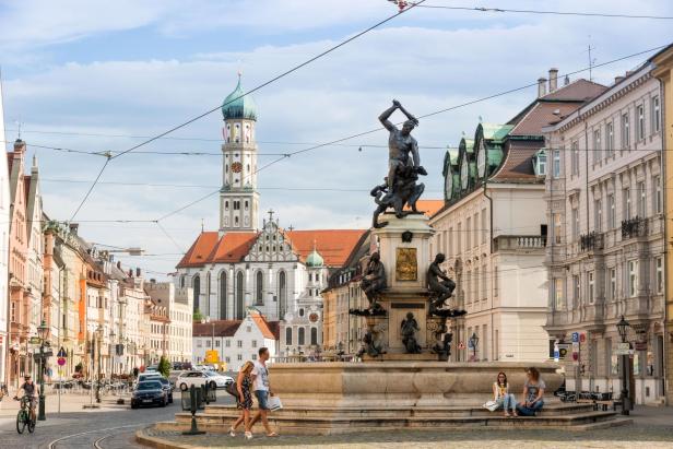 Der Augsburger Augustusbrunnen mit der St. Ulrich Kirche im Hintergrund.