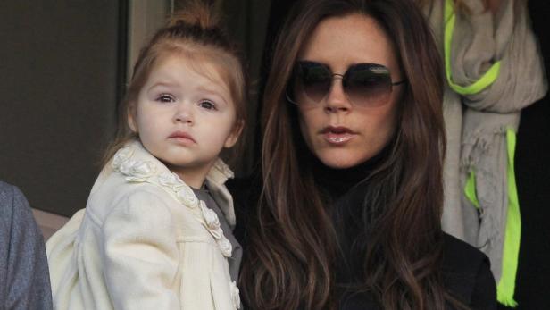 Victoria Beckham mit ihrer Tochter Harper in einem hellen Mantel.