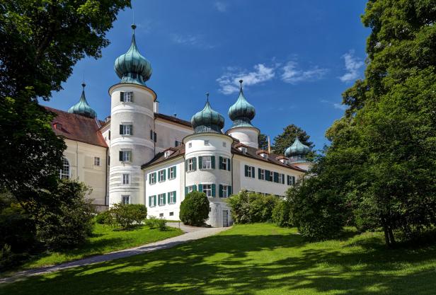 Das Schloss Mattsee mit seinen charakteristischen Zwiebeltürmen und grünen Fensterläden.