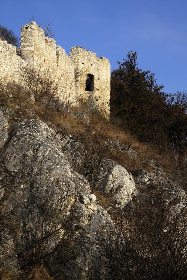 Die Ruine einer Burg thront auf einem felsigen Hügel.