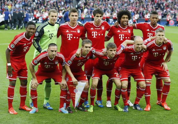 Die Mannschaft des FC Bayern München posiert auf dem Rasen.