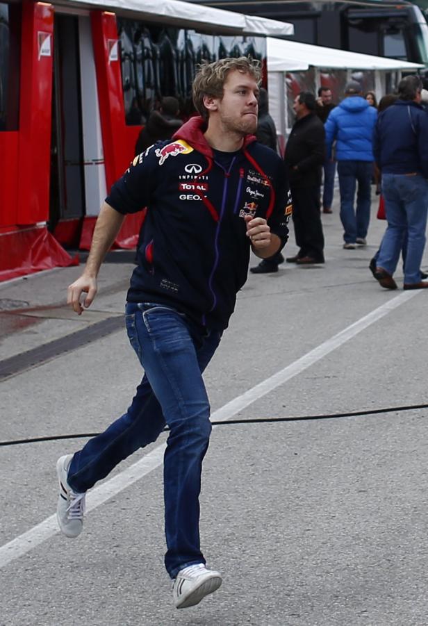 Sebastian Vettel läuft in Jeans und einer Red Bull Jacke.