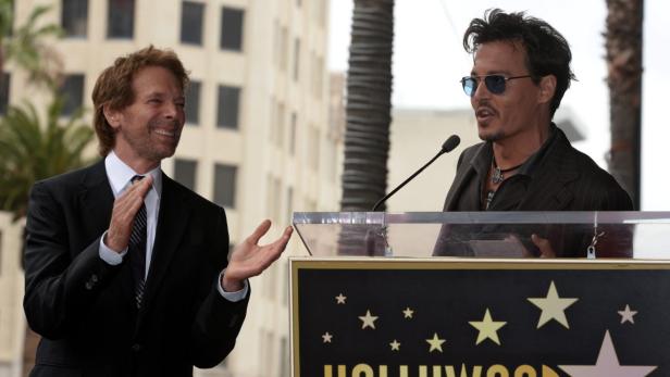 Johnny Depp spricht am Hollywood Walk of Fame, während Jerry Bruckheimer applaudiert.