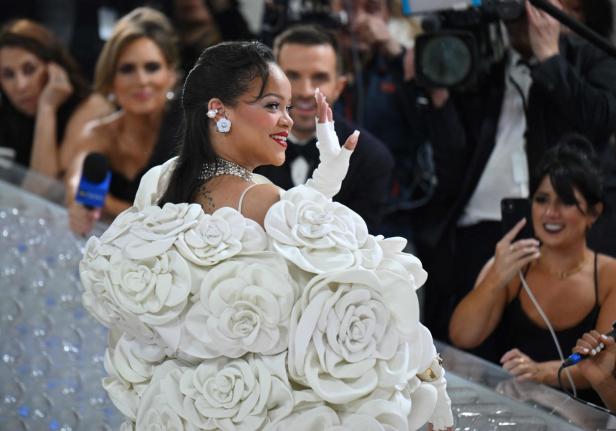 Rihanna in einem weißen, blumenverzierten Kleid auf dem roten Teppich.
