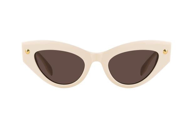 Eine cremefarbene Cat-Eye-Sonnenbrille mit braunen Gläsern und goldenen Akzenten.