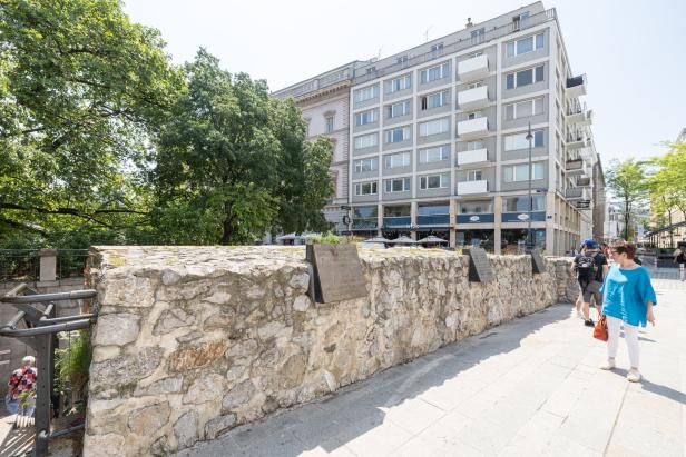 Ein Teil der alten Stadtmauer von Krakau mit Passanten im Hintergrund.