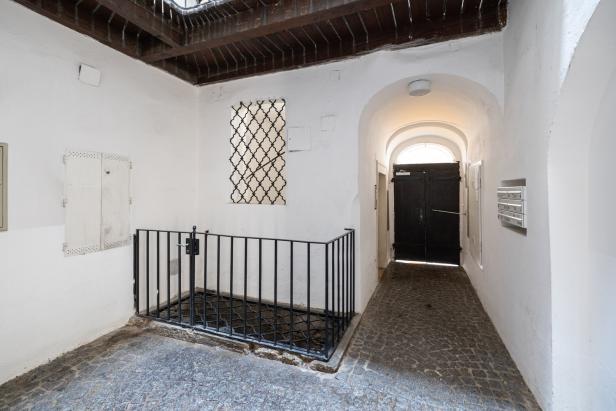 Ein Innenhof mit Kopfsteinpflaster und einem schwarzen Gitter.