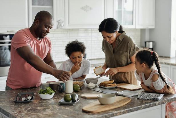 Eine Familie bereitet gemeinsam das Frühstück in der Küche zu.