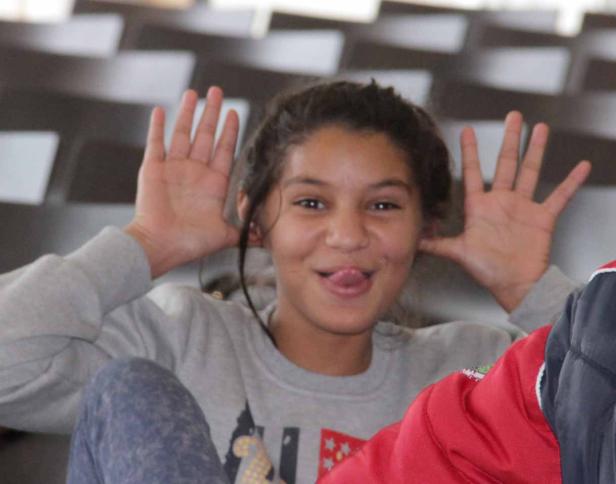 Ein junges Mädchen macht Grimassen und streckt die Zunge heraus.