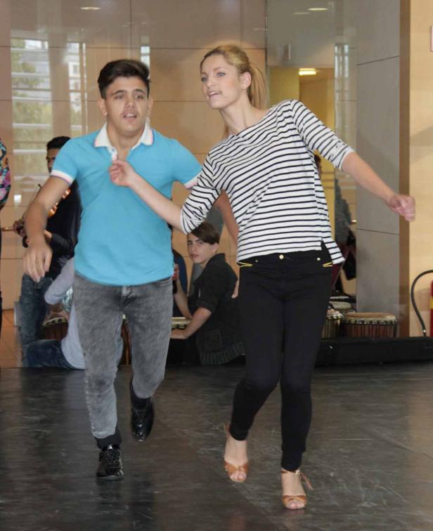 Ein junges Paar tanzt auf einer Bühne.