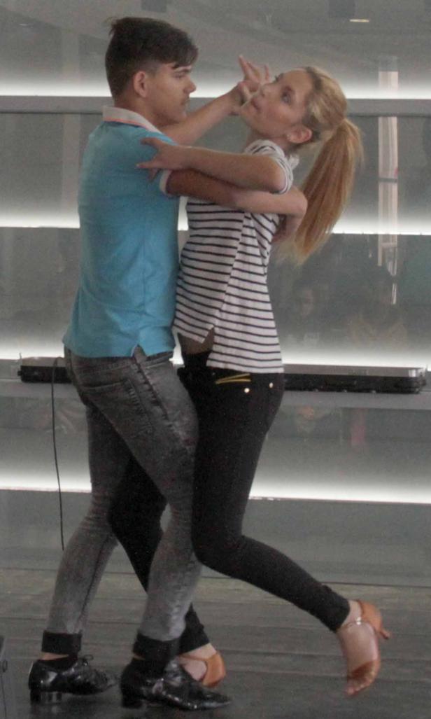 Ein Paar tanzt in Tanzschuhen eng umschlungen.