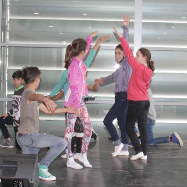 Eine Gruppe von Kindern tanzt auf einer Bühne.