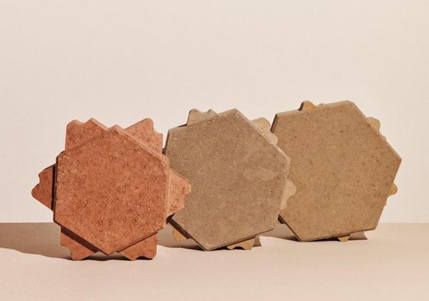 Drei sechseckige Pflastersteine in verschiedenen Erdtönen stehen nebeneinander.