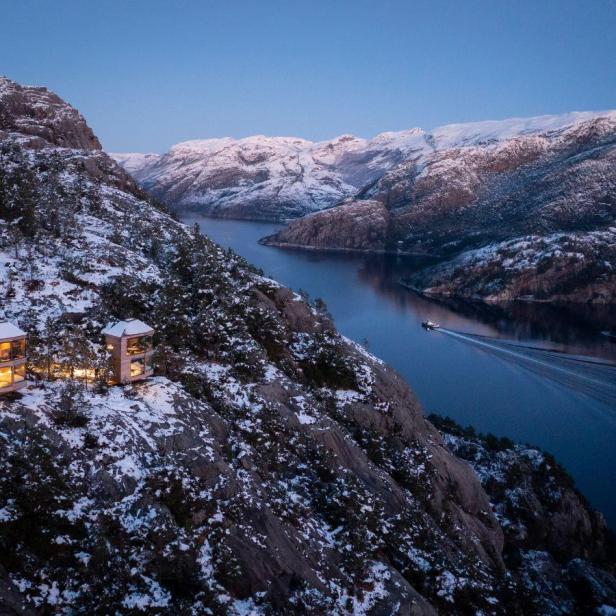 Die Bolder Star Lodge liegt an einem Hang mit Blick auf einen Fjord und schneebedeckte Berge.