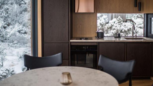 Blick aus einer modernen Küche auf eine verschneite Landschaft.
