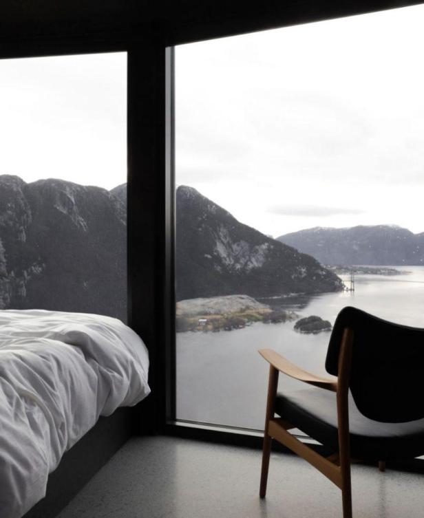 Ein Schlafzimmer mit Blick auf einen See und Berge.