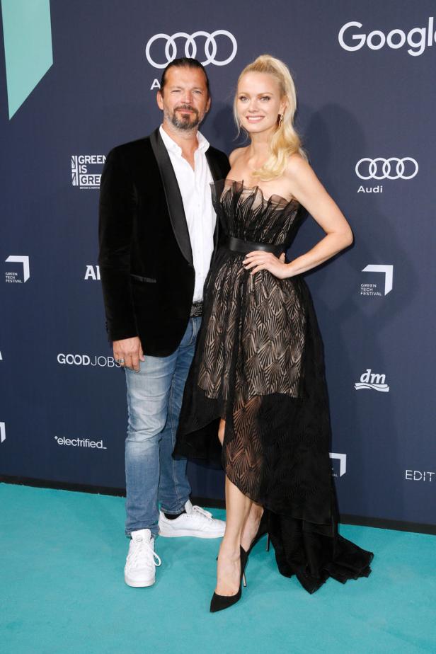 Ein Mann im Sakko und eine Frau im Abendkleid posieren auf dem Green Tech Festival.