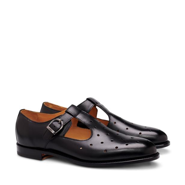 Ein Paar schwarze Mary-Jane-Schuhe aus Leder mit Schnalle und Lochmuster.