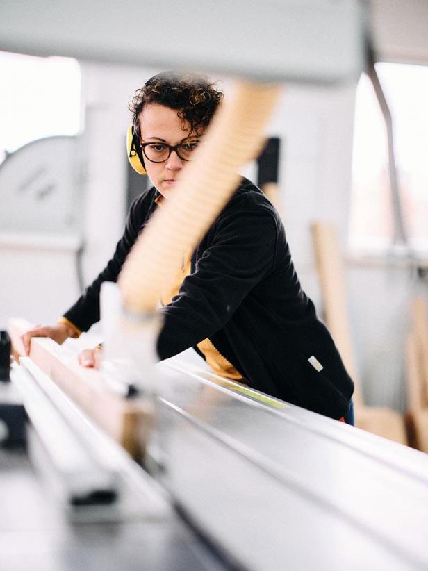 Katja Kammerer arbeitet mit Gehörschutz an einer Tischsäge.