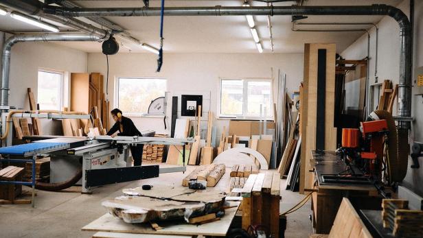 Katja Kammerer arbeitet mit Gehörschutz an einer Tischsäge in einer Werkstatt.