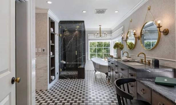 Ein luxuriöses Badezimmer mit Marmordusche, freistehender Badewanne und Doppelwaschtisch.