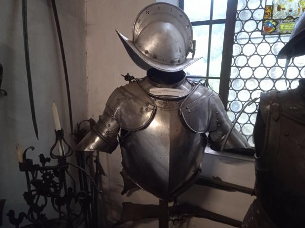 Ein polierter Harnisch mit Helm steht vor einem Fenster.