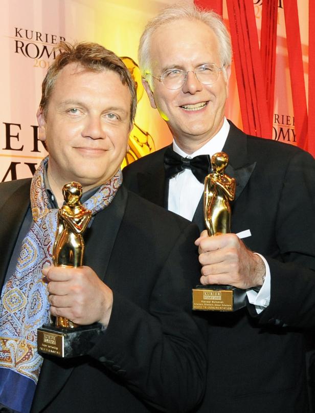 Harald Schmidt und ein weiterer Mann halten jeweils eine Romy-Trophäe in den Händen.