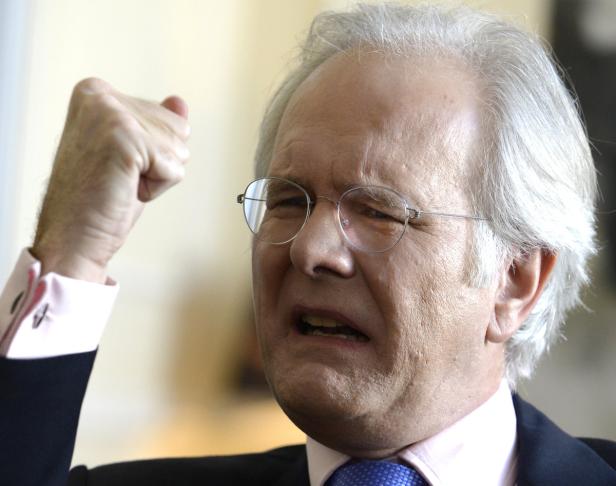 Ein Mann mit Brille ballt die Faust und blickt grimmig.