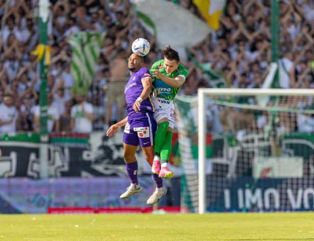 Zwei Fußballspieler kämpfen in der Luft um den Ball.