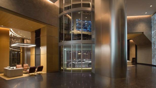 Ein Porsche steht in einem gläsernen Aufzug im Porsche Design Tower in Miami.