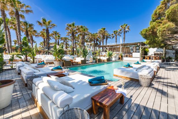Das Nikki Beach in Saint-Tropez mit Pool und Liegen unter Palmen.