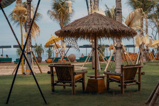 Blick auf den Potato Head Beach Club auf Bali mit Strohschirmen und Bambusmöbeln.