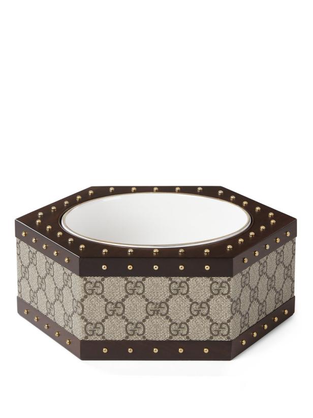 Eine sechseckige Schale mit dem Gucci-Logo und goldenen Ziernieten.