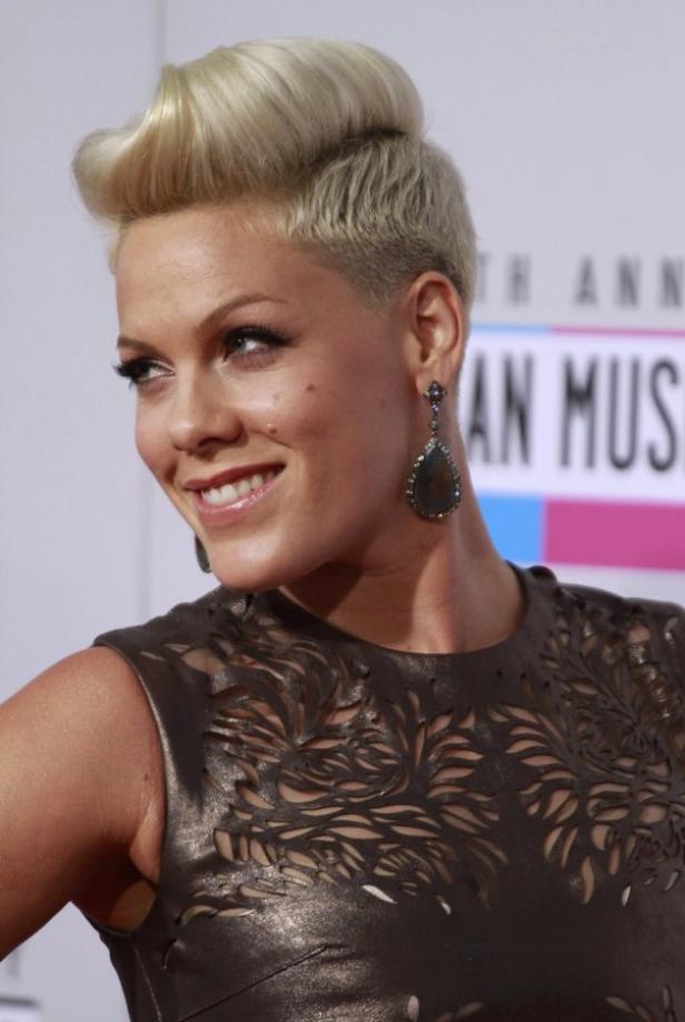 Die Sängerin Pink mit blonden Haaren und einem schwarzen Kleid mit floralem Muster.