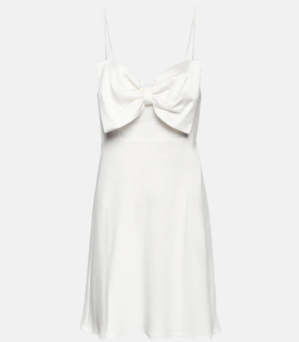 Ein weißes Minikleid mit einer großen Schleife am Oberteil.