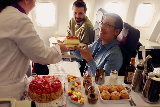 Ein Mann erhält ein Stück Erdbeerkuchen an Bord eines Flugzeugs.