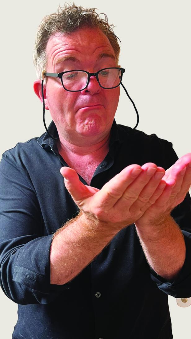 Ein Mann mit Brille hält seine Hände wie zum Empfangen von etwas hin.