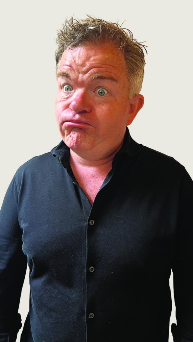 Ein Mann mit hochgezogenen Augenbrauen und zusammengepressten Lippen blickt in die Kamera.