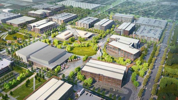 Eine Luftaufnahme eines großen Gewerbegebietes mit mehreren Gebäuden und Grünflächen.