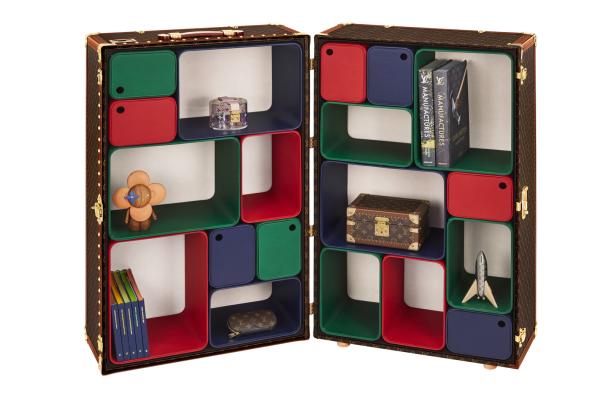 Ein geöffneter Louis Vuitton Koffer dient als Regal mit bunten Fächern und verschiedenen Deko-Objekten.