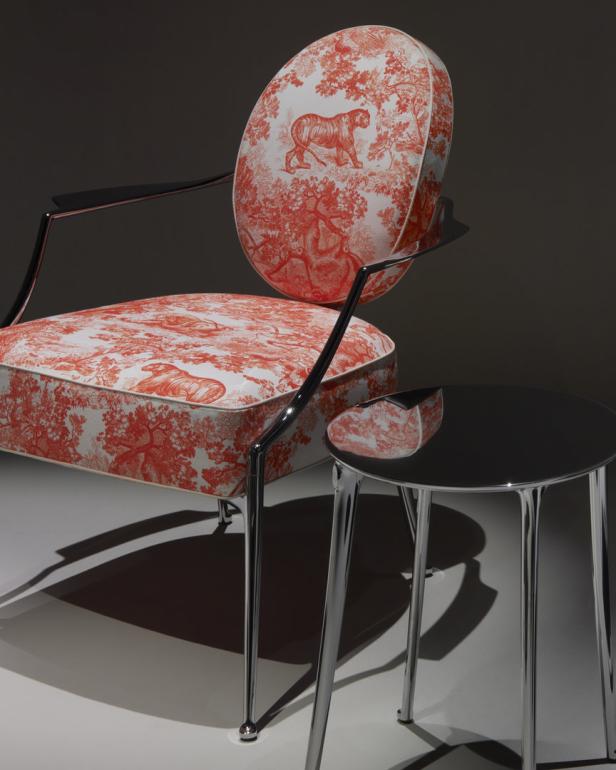 Ein Stuhl mit Tiger-Toile-de-Jouy-Muster steht neben einem kleinen, runden Tisch.